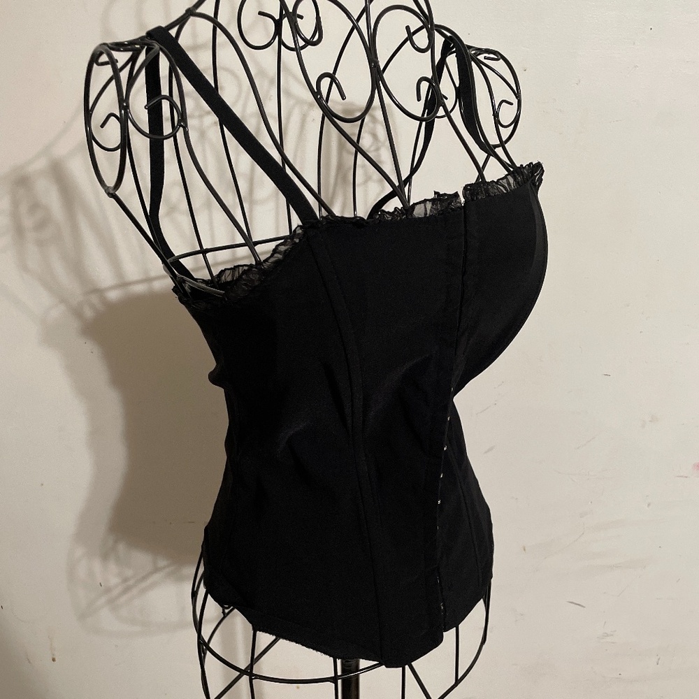 Black corset with metal ribbing and closure hooks in the front